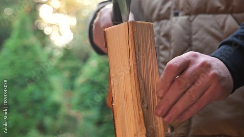 man chops wood on a large stump outside. close-up of the axes work. Heating season. Solid heating fuel.Preparing firewood for the heating season