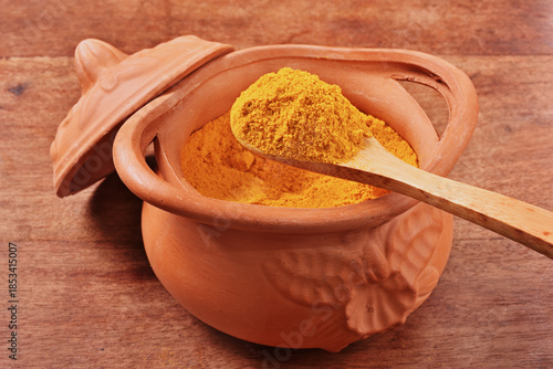 Dry curry powder in bowl on wooden table