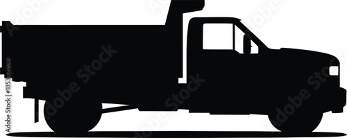 a stark black silhouette of a heavy duty dump truck is prominently featured standing still on a flat surface creating a powerful visual