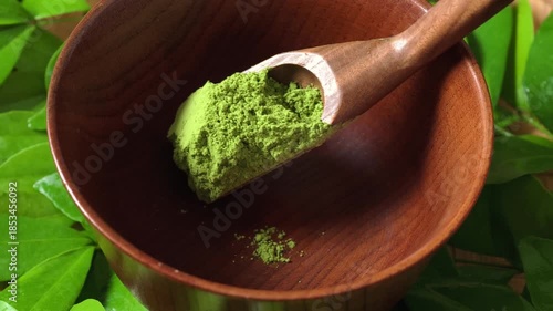 Matcha green tea in a wooden spoon.