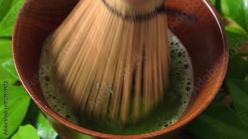 Process making matcha green tea. Mixing matcha tea with whisk in wooden bowl. Healthy matcha drinks	