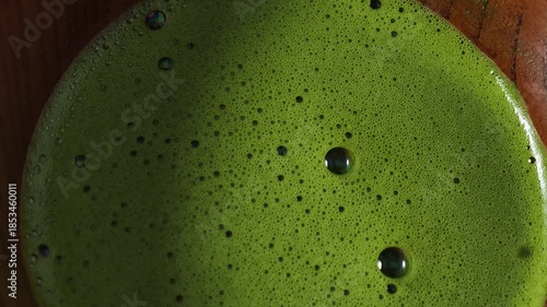 Process making matcha green tea. Mixing matcha tea with whisk in wooden bowl. Healthy matcha drinks	