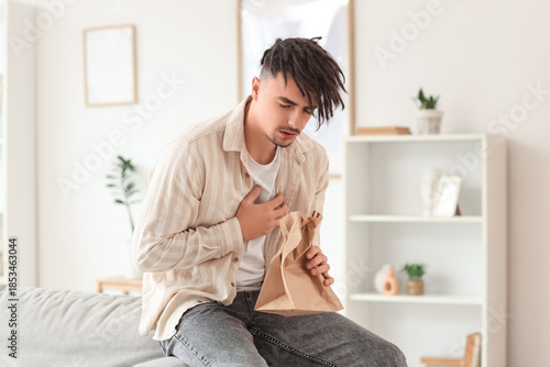Young man with paper bag ha...