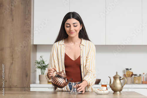 Young woman pouring Turkish...