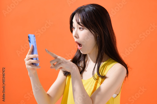 スマホを持って驚く女性