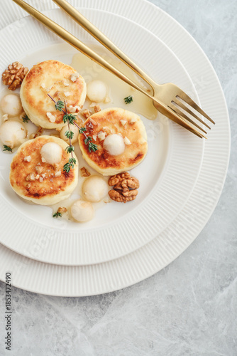 cottage cheese pancakes, syrniki, curd fritters with pear balls, walnut and honey