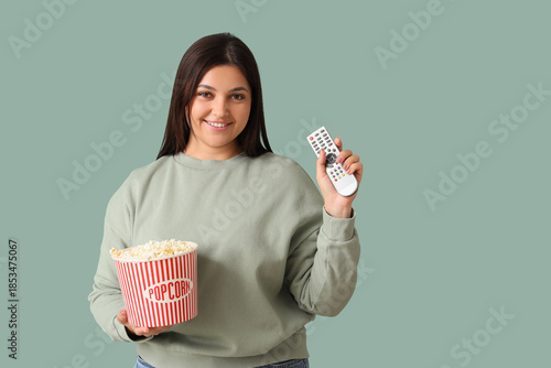 Young woman with TV remote ...