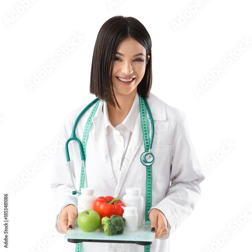 Female nutritionist holding weight scales with healthy food and pill bottles ...