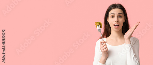 Surprised young woman holdi...
