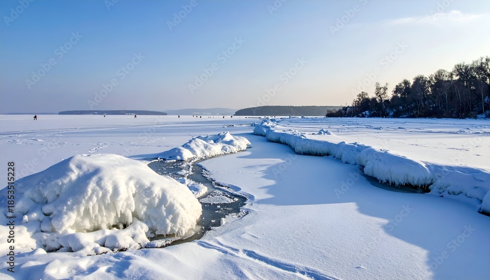 Obraz premium Frozen lake with a path of open water and snowy formations under a bright blue sky