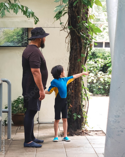 Little girl pointing on something to the father in the water park in Malaysia.