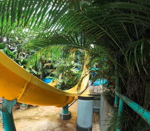 Yellow slide among the tropical trees, a water park in Malaysia.