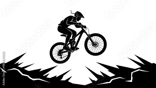 Silhouette of a mountain biker performing a jump on a downhill trail