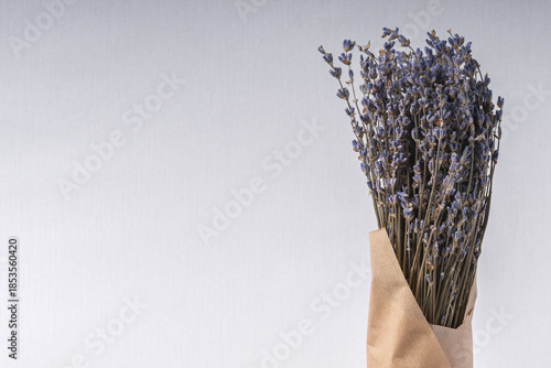 A bunch of lavender in craft paper on a light background with copy space.