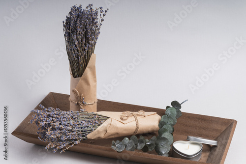 Wooden tray with lavender bunches and heart-shaped candles. A serene atmosphere, calm, and relaxation.
