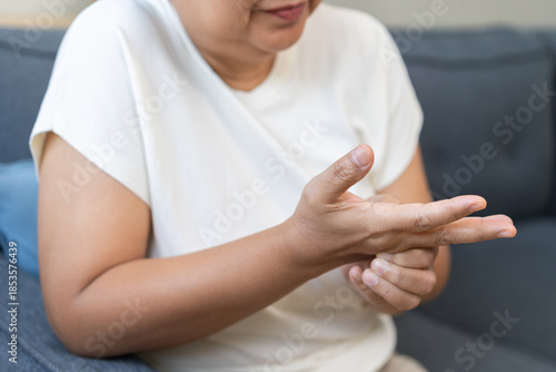 Health care concept, rheumatism asian senior woman hand pain from cramp, trigger finger, wrist pain touching massaging, aged hand holding ache joint, arthritis inflammation.Chronic disease from injury