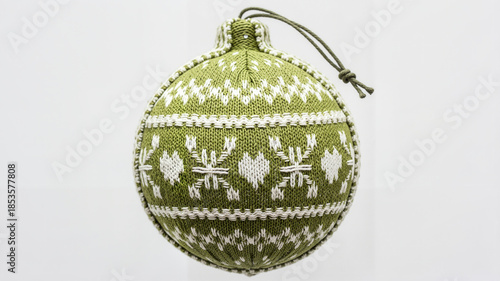 Green knitted Christmas ornament with snowflake pattern hanging  