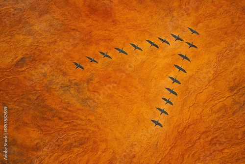 Migratory Birds in V-Formation Over Orange Landscape at Sunset