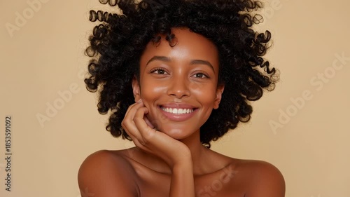 Radiating joy and confidence, an African American woman poses gracefully against a warm background. Her playful curls frame her face as she shares an enchanting smile, embodying beauty and strength
