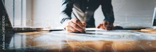 A professional working on a project with a laptop and creative design materials.