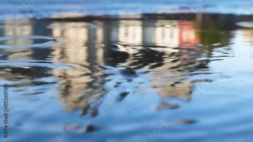 Distorted reflection of building facades on rippled water surface