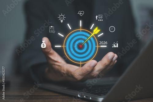 Businessman hand holding virtual 2026 target board. Concept of business goal setting, future strategy planning, marketing vision, objective achievement, and financial success.
