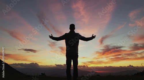 Silhouette of a person raising hands at sunset, embodying achievement, freedom, and connection with nature