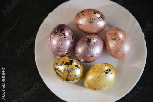 Wallpaper Mural Painted eggs lie on a white plate, top view, preparation for the Easter holiday Torontodigital.ca
