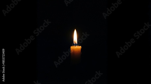 A serene candlelit moment in a darkened space with a single flame burning brightly