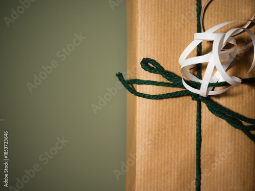 Christmas gift with wrapping ribbon and string green background
