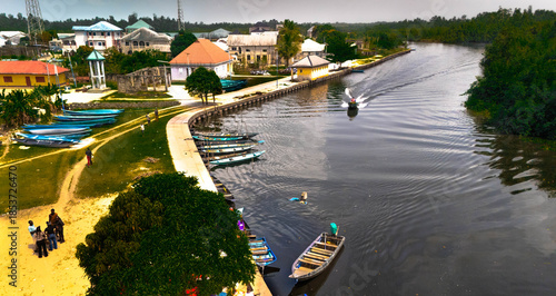 Aerial view of a water channel cuts through the town with boats docked, creating a vibrant contrast between the natural waterway and the settlement, Abonnema, Port Harcourt, Nigeria.