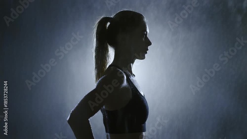 Silhouette of a Determined Woman Exercising in the Rain.