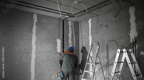 Skilled Worker Performs Installation Of Electrical Conduits Into Concrete Ceiling During Renovation