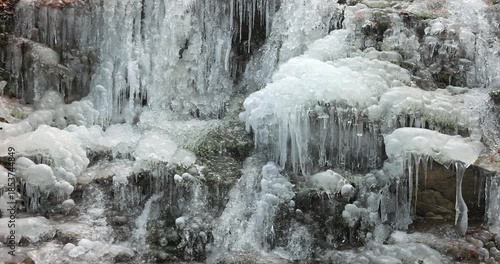 Wallpaper Mural Frozen Waterfall: A cascade of crystal icicles clings to the rugged rocks, capturing the beauty of winter's icy grip, transforming nature into a frozen spectacle. Torontodigital.ca