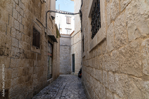 Stare zabytkowe kamienice i uliczki w mieście Trogir w Chorwacji z pięknymi oknami i okiennicami. 