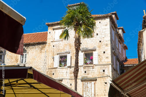 Stare zabytkowe kamienice i uliczki w mieście Trogir w Chorwacji z pięknymi oknami i okiennicami. 