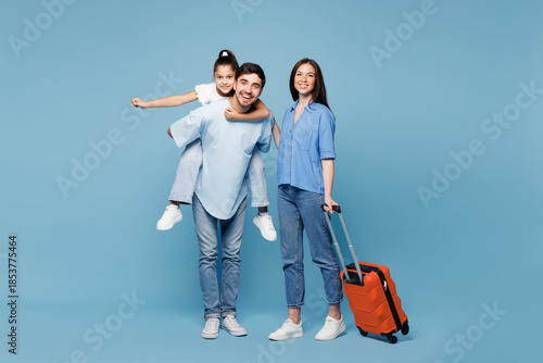 Traveler young fun parents mom dad child wear casual clothes hold suitcase bag isolated on plain blue background. Tourist travel abroad in free spare time rest getaway Air flight trip journey concept