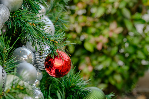 christmas tree decoration with many colorful shiny winkle balls in the garden