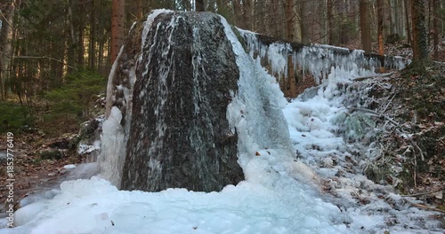 Wallpaper Mural Frozen waterfall cascading over mossy rocks and down the forest hillside. Beautiful display of winter grandeur as ice art forms, with woods in the background. Torontodigital.ca