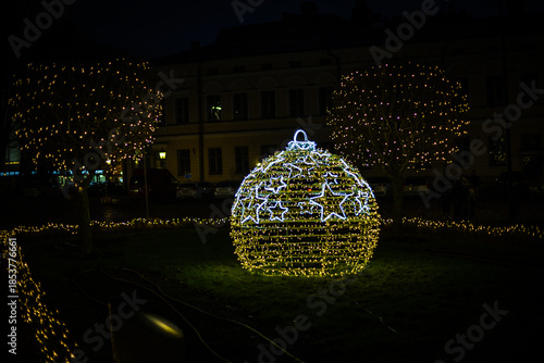 Photo of New Year street lanterns decorated with festive lights on a winter street at night. Warm illumination and holiday decorations create a cozy seasonal atmosphere, ideal for Christmas and New