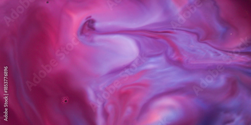 An abstract background of liquid marble texture in a vibrant blend of magenta, purple, and blue. The flowing effect of ink or paint blending gently creates an artistic and imaginative visual compositi