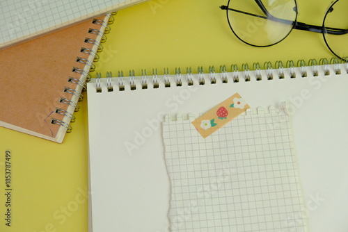 Open blank spiral notebook with black pencil on yellow background. Empty Space for your text. business and education concept