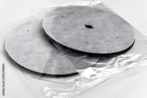 Packaged round industrial filtration discs in transparent plastic. Clean water system components. Household maintenance supplies