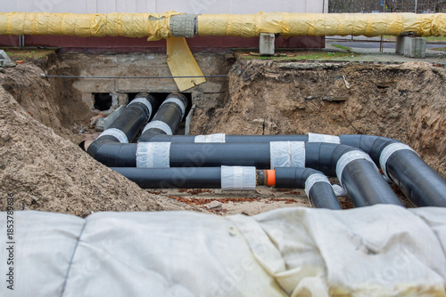 Photography Insulated district heating pipes installation in deep urban trench