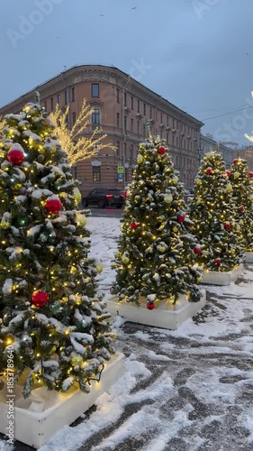 Saint Petersburg in December. Vertical video of New Year and Christmas decorations in form of row of sparkling Christmas trees with colorful balls on St. Isaac Square on winter day