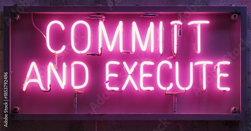 Bright pink neon sign displays text commit and execute. Dark background emphasizes glowing message. Simple, direct presentation.