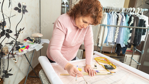 Картината върху платно tailor putting a dress pattern ina sewing workshop, the process of sewing new clothes