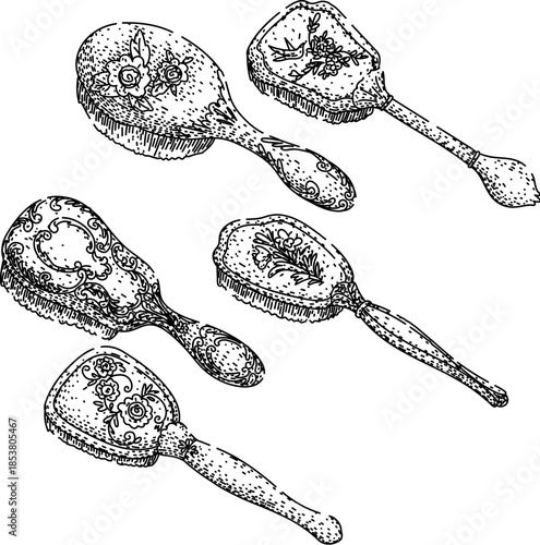 Collection of five antique hand drawn hair and grooming brushes displaying intricate floral and baroque style decorations, illustrating classic beauty and personal care items