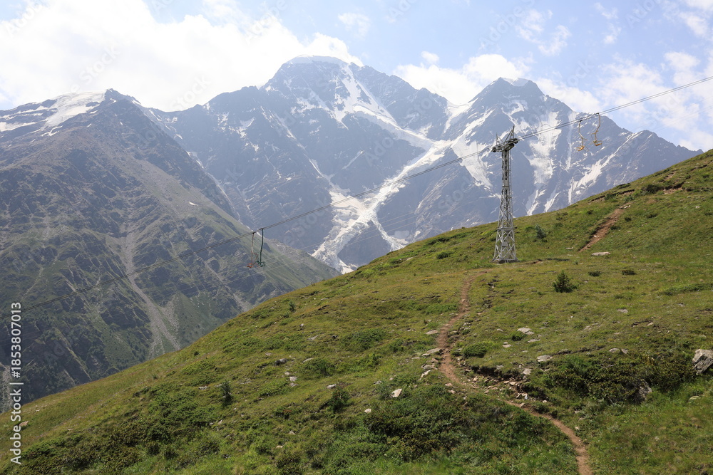 Naklejka premium Cheget mountain landscape with a ski lift tower and green slope
