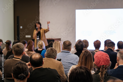 Wallpaper Mural Audience listens to a speaker during conference presentation in a large room with a bright screen. Torontodigital.ca